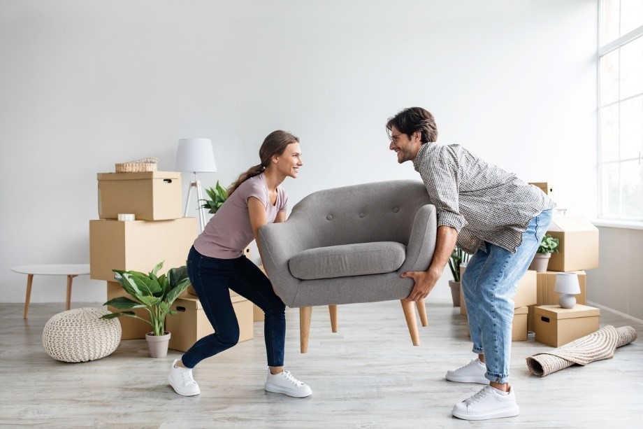 couple moving couch into new home
