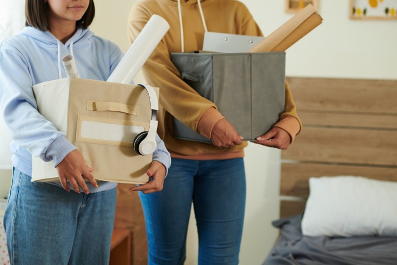 students holding boxes moving into student accommodation